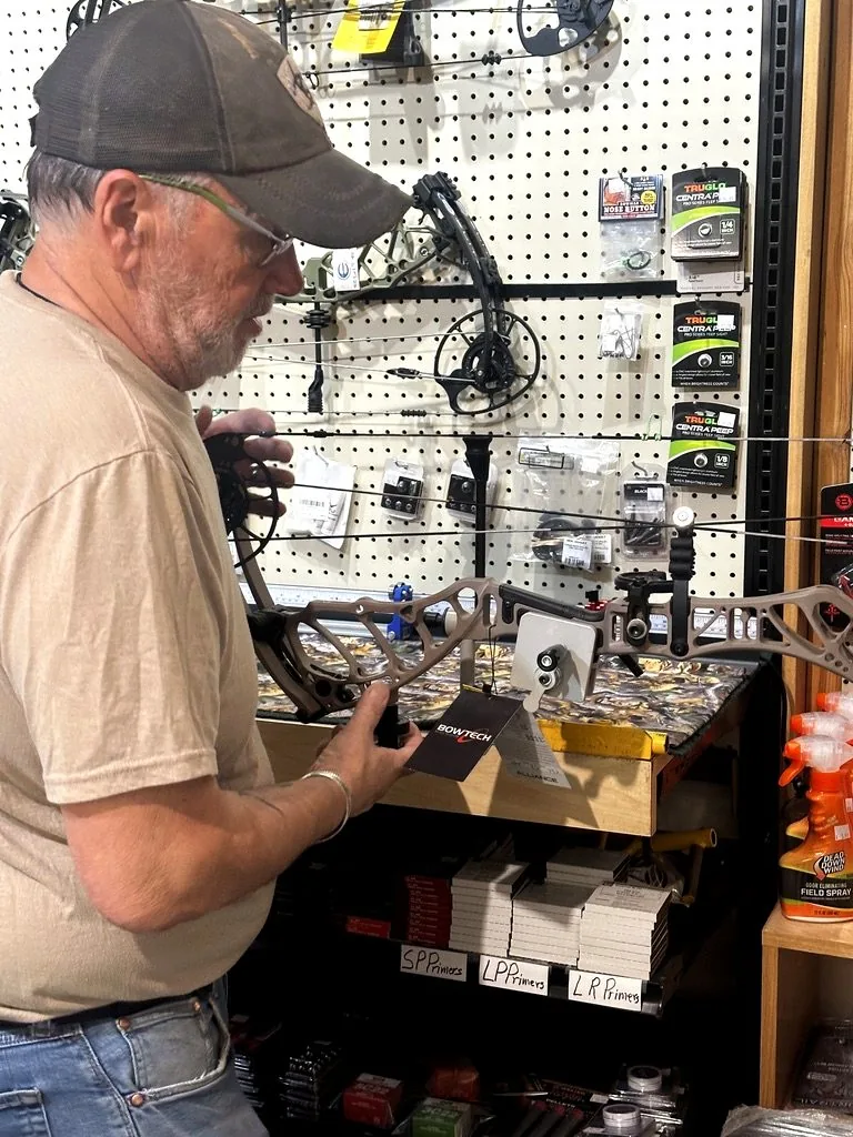Close-up of a compound bow being adjusted and set up